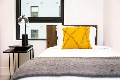 a bed with a yellow pillow next to a window at Lucid Lemming in Revelstoke