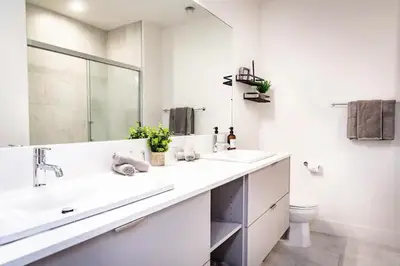 a white bathroom with two sinks and a mirror at Lucid Lemming in Revelstoke