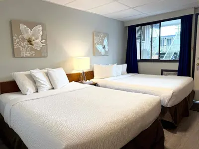 a hotel room with two beds and a window at Departure Bay Motel in Nanaimo