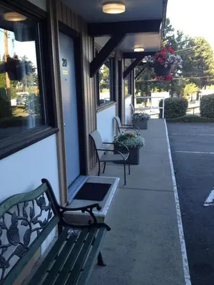 two benches sitting outside of a building at Departure Bay Motel in Nanaimo