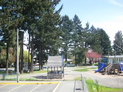 a park with a playground with a blue slide at Departure Bay Motel in Nanaimo