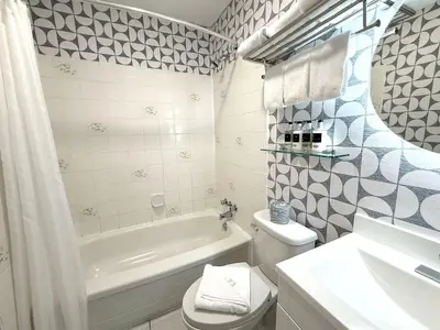 a bathroom with a tub and a toilet and a sink at Departure Bay Motel in Nanaimo