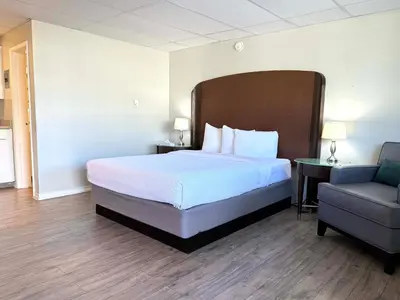 a hotel room with a bed and a chair at Departure Bay Motel in Nanaimo