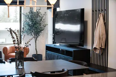 a dining room with a table and a television at Knuckle Hucks by Revelstoke Vacations in Revelstoke
