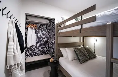 a bedroom with a bunk bed and a bed with at Knuckle Hucks by Revelstoke Vacations in Revelstoke