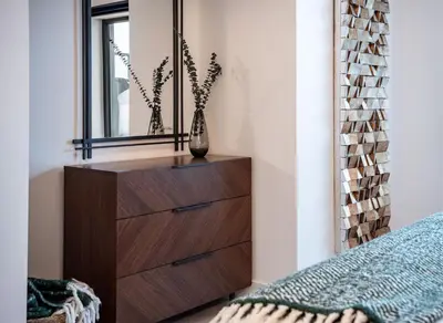 a bedroom with a dresser and a mirror at Knuckle Hucks by Revelstoke Vacations in Revelstoke
