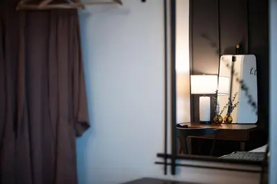 a mirror in a bedroom with a table and a lamp at Knuckle Hucks by Revelstoke Vacations in Revelstoke