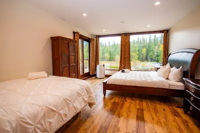 a bedroom with a bed and a large window at River Safari Mountain View Suite in Blue River