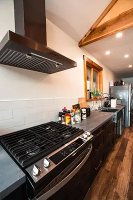a kitchen with a black stove top oven at River Safari Mountain View Suite in Blue River