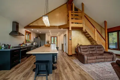 a kitchen with a large island and a stairway at River Safari Mountain View Suite in Blue River