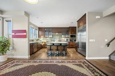 a large kitchen with a counter and stools at Golden View Manor in Calgary