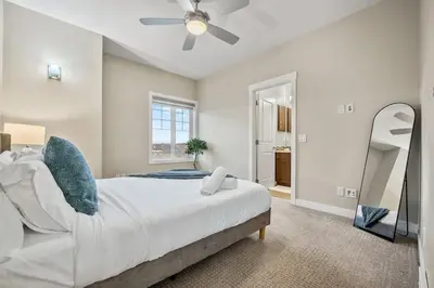 a bedroom with a large bed and a ceiling fan at Golden View Manor in Calgary