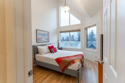 a bedroom with a bed and a window at Alpine Village Condo by Canadian Rockies Vacation Rentals in Canmore