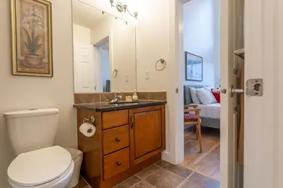 a bathroom with a toilet and a sink with a mirror at Alpine Village Condo by Canadian Rockies Vacation Rentals in Canmore