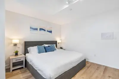 a bedroom with a large white bed with blue pillows at Spacious Family Retreat Central to YVR and Downtown in Vancouver