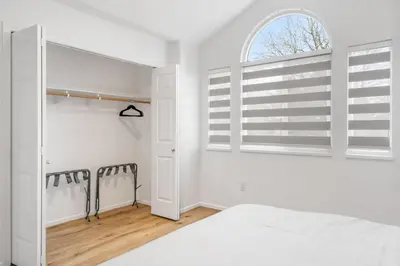 a white bedroom with a bed and a window at Spacious Family Retreat Central to YVR and Downtown in Vancouver
