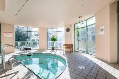 a hot tub in a room with windows at Beautiful condo beach side Yaletown in Vancouver