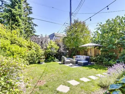 a garden with a couch and an umbrella at Private Suite With Spacious Yard in Vancouver