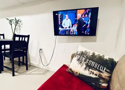a living room with a couch and a tv on the wall at Private Suite With Spacious Yard in Vancouver