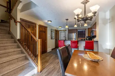 a dining room and kitchen with a table and chairs at Stunning Central Canmore Condo in Canmore