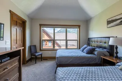 a bedroom with a bed and a window at Newly Renovated Rocky Mountain Canmore Chalet in Canmore