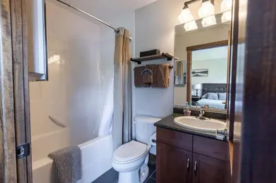a bathroom with a toilet and a sink and a mirror at Newly Renovated Rocky Mountain Canmore Chalet in Canmore