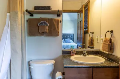 a bathroom with a sink and a toilet and a mirror at Newly Renovated Rocky Mountain Canmore Chalet in Canmore