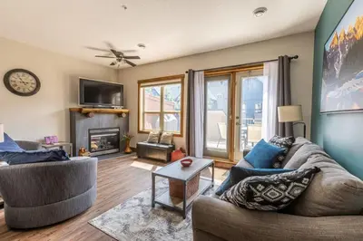 a living room with a couch and a fireplace at Newly Renovated Rocky Mountain Canmore Chalet in Canmore
