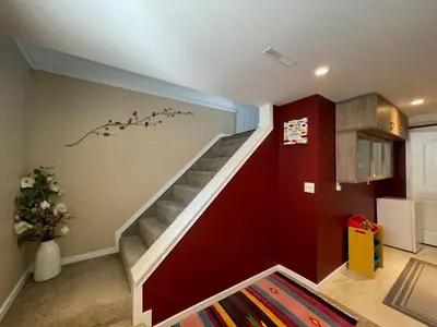 a staircase in a house with a red wall at Welcome to Shibly's Retreat in Edmonton