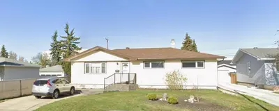 a white house with a car parked in front of it at Welcome to Shibly's Retreat in Edmonton