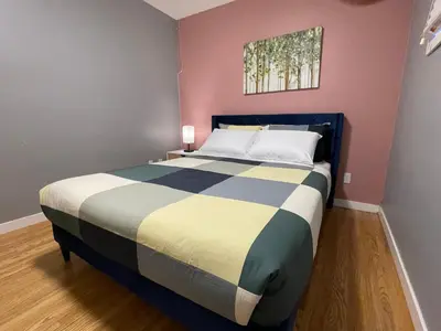 a bedroom with a large bed in a room with pink walls at Welcome to Shibly's Retreat in Edmonton