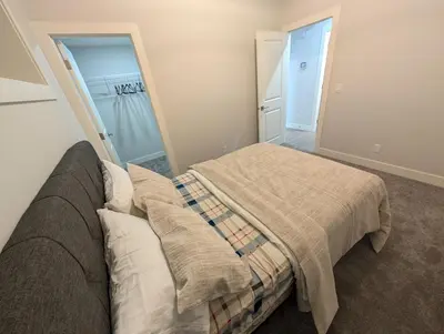 a bedroom with a bed with a blanket at DaraJay Cozy Home in Calgary