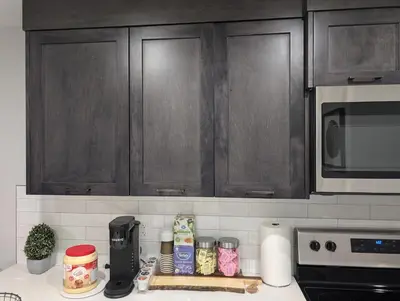 a kitchen with wooden cabinets and a counter top with food at DaraJay Cozy Home in Calgary