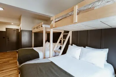 two beds in a room with two bunk beds at The Flying Steamshovel Inn in Rossland