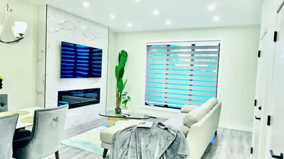 a living room with a table and chairs at 3 Story Luxury Cozy Sleek Home in Edmonton