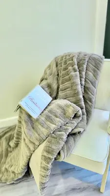 a book sitting on top of a blanket on a couch at 3 Story Luxury Cozy Sleek Home in Edmonton