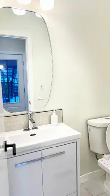 a white bathroom with a sink and a mirror at 3 Story Luxury Cozy Sleek Home in Edmonton