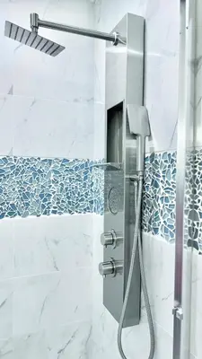 a shower with blue and white tiles in a bathroom at 3 Story Luxury Cozy Sleek Home in Edmonton