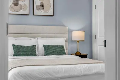 a bedroom with a white bed with two green pillows at West King Edward Luxury Guest Home in Vancouver