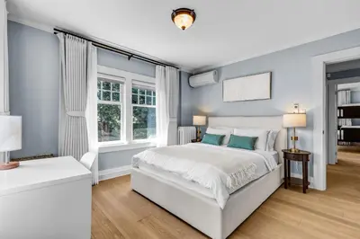 a blue bedroom with a bed and a window at West King Edward Luxury Guest Home in Vancouver
