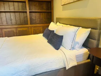 a bed with two pillows on top of it at West King Edward Luxury Guest Home in Vancouver