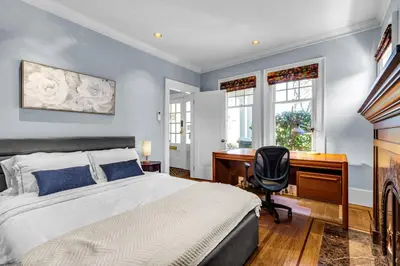 a bedroom with a bed and a desk and a chair at West King Edward Luxury Guest Home in Vancouver