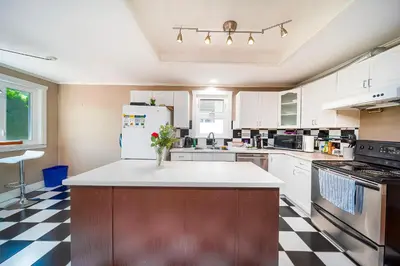 a kitchen with a refrigerator and a counter top at Charming 3BR Home Near UBC with Parking & Backyard in Vancouver