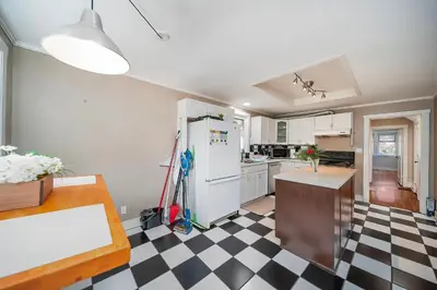 a kitchen with a white refrigerator and a checkered floor at Charming 3BR Home Near UBC with Parking & Backyard in Vancouver