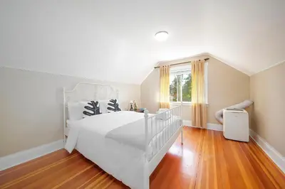 a white bedroom with a white bed and a window at Charming 3BR Home Near UBC with Parking & Backyard in Vancouver