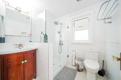 a white bathroom with a toilet and a sink at Charming 3BR Home Near UBC with Parking & Backyard in Vancouver