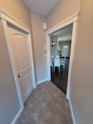 a hallway with a door and a dining room at Sean Comfy Home in Edmonton