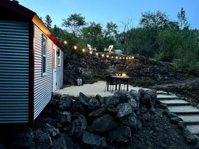 a patio with a table and some lights and rocks at Runaway Express Coach in Oliver