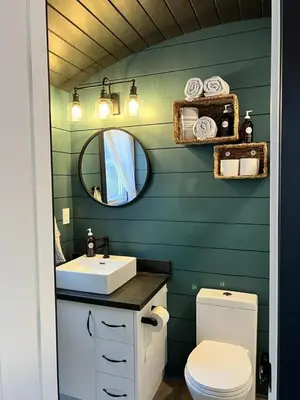 a bathroom with a sink and a toilet and a mirror at Runaway Express Coach in Oliver