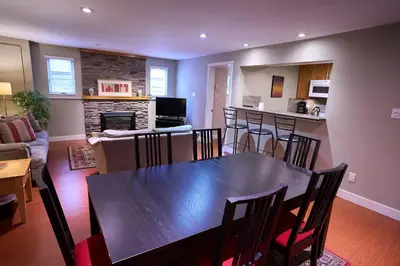 a dining room and living room with a table and chairs at Awesome 2BR in Lynn Valley in North Vancouver